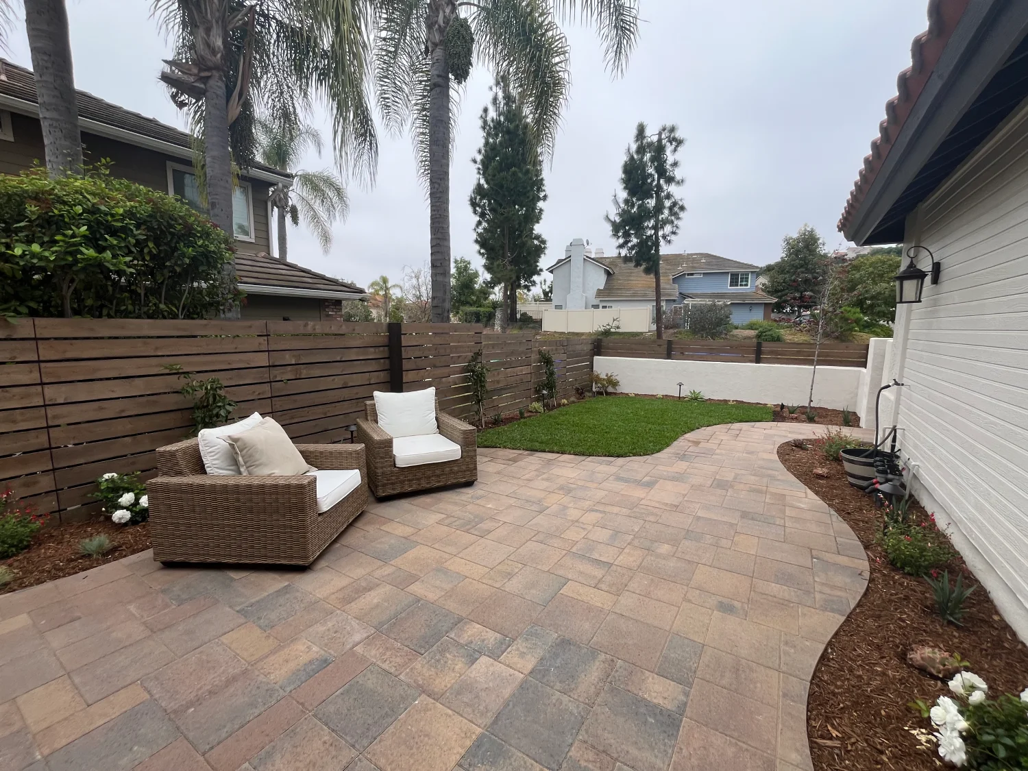 Curved paver patio with outdoor furniture in Rancho Bernardo front yard renovation.